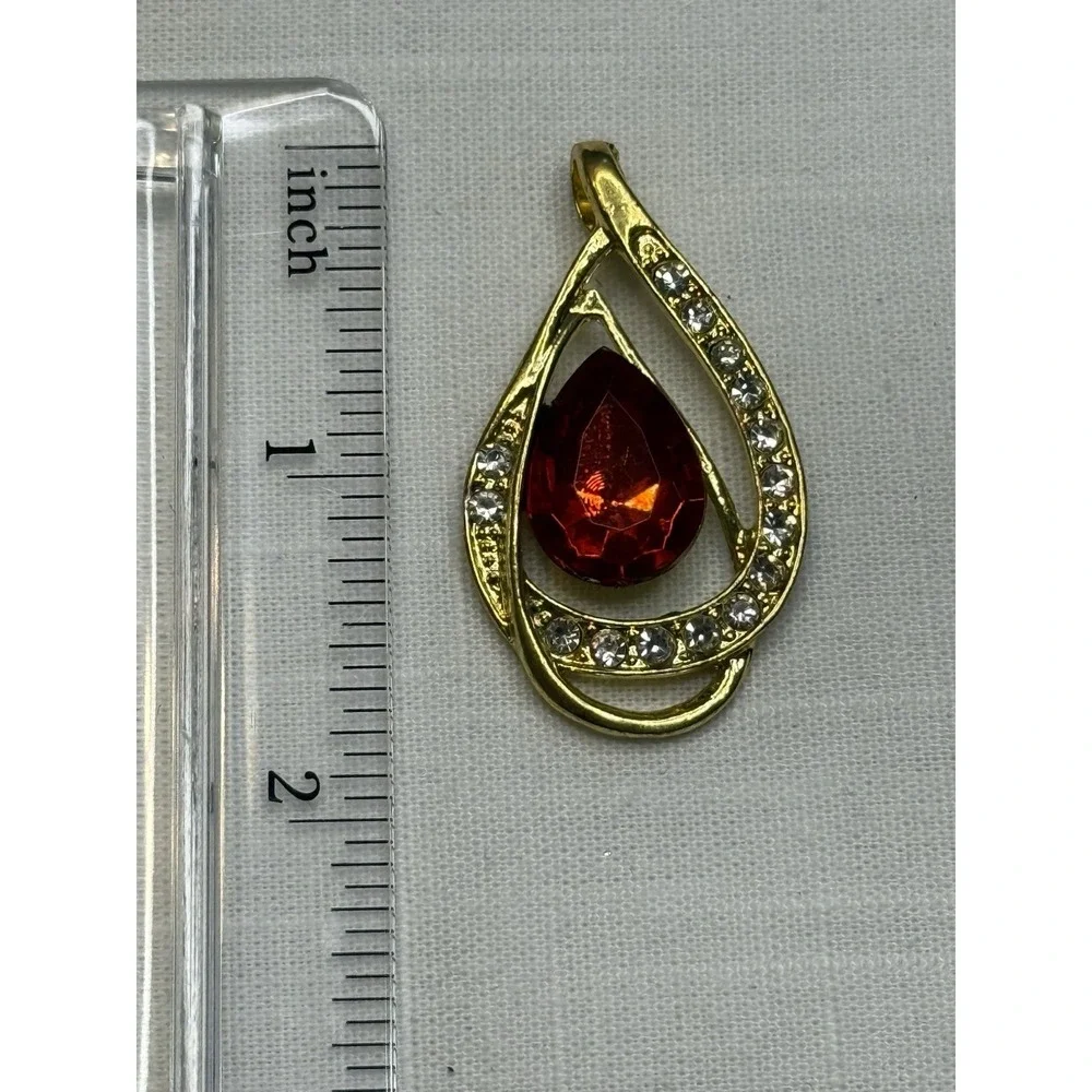 Gold tone red gem & rhinestone pendant
